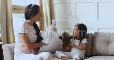 可爱的亚洲女孩戴着皇冠和妈妈玩木偶